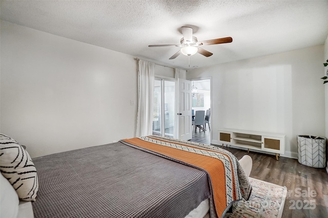 bedroom featuring a textured ceiling, ceiling fan, and dark hardwood / wood-style floors