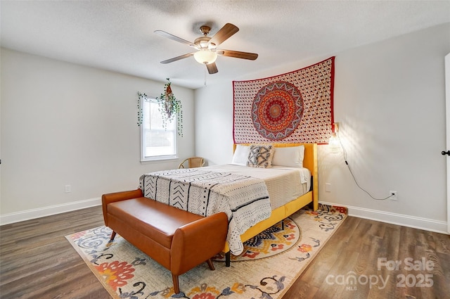 bedroom featuring dark wood-type flooring, ceiling fan, and a textured ceiling