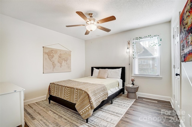 bedroom featuring a textured ceiling, ceiling fan, and hardwood / wood-style floors