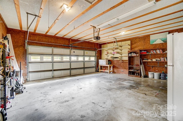 garage with a garage door opener and white fridge