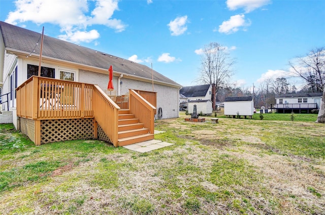 rear view of property featuring a wooden deck and a yard