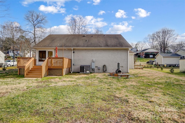 back of house with a wooden deck and a lawn