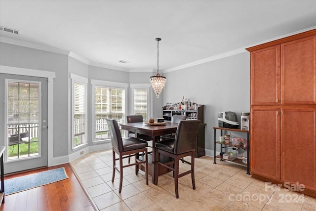 dining room featuring crown molding, light hardwood / wood-style flooring, and a healthy amount of sunlight