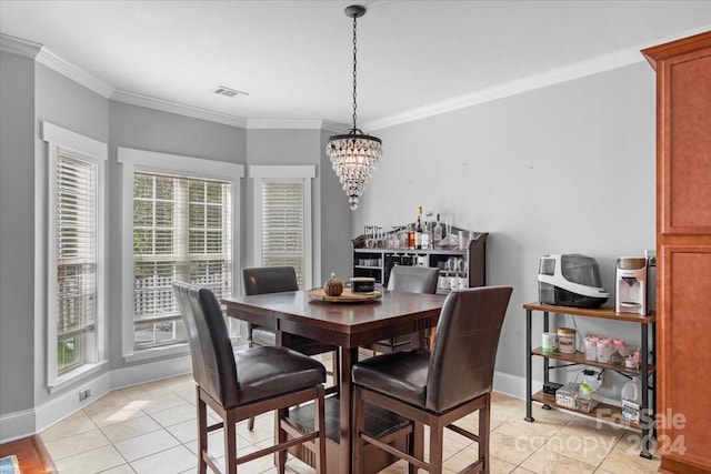 dining room with light tile patterned floors, an inviting chandelier, and crown molding