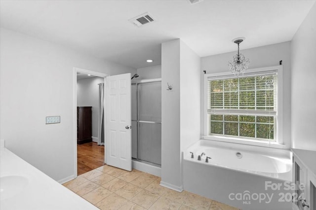 bathroom with vanity, hardwood / wood-style floors, plus walk in shower, and an inviting chandelier