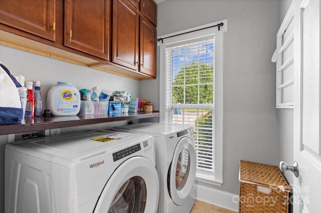 laundry room with cabinets, washing machine and dryer, and light tile patterned floors