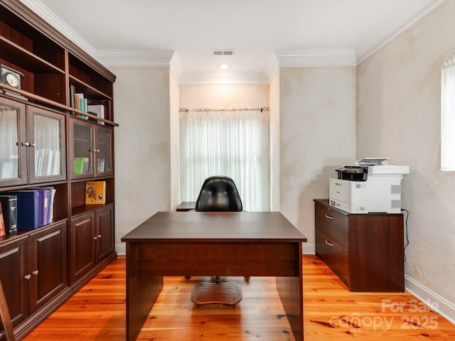 office featuring light wood-style flooring, visible vents, baseboards, and ornamental molding