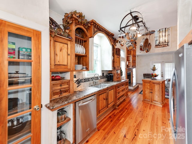 kitchen featuring open shelves, appliances with stainless steel finishes, plenty of natural light, and a sink