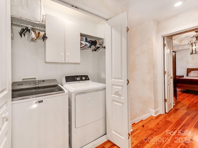 laundry area featuring light wood finished floors, independent washer and dryer, cabinet space, and recessed lighting