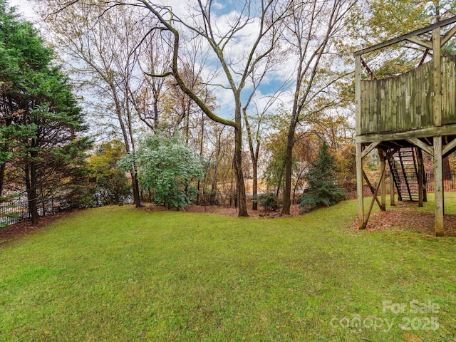 view of yard featuring fence and stairs