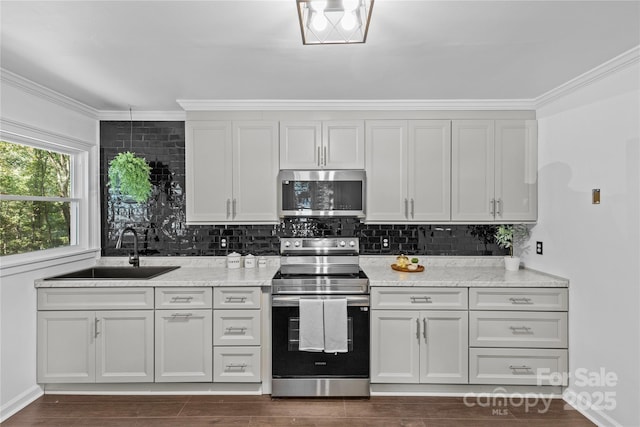 kitchen with light stone countertops, sink, stainless steel appliances, and ornamental molding