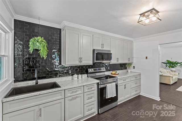 kitchen featuring light stone countertops, sink, dark hardwood / wood-style flooring, decorative backsplash, and appliances with stainless steel finishes