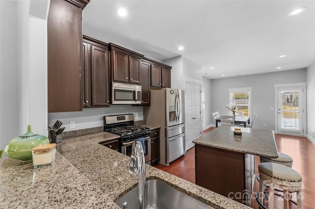 3157 Delaware Dr, Denver, NC 28037 - kitchen featuring appliances with stainless steel finishes, a center island, light stone counters, and dark brown cabinetry