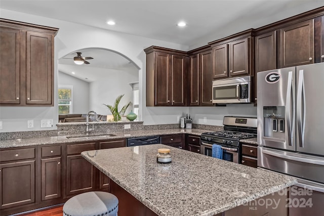 3157 Delaware Dr, Denver, NC 28037 - kitchen featuring dark brown cabinetry, light stone counters, appliances with stainless steel finishes, a kitchen island, and a sink