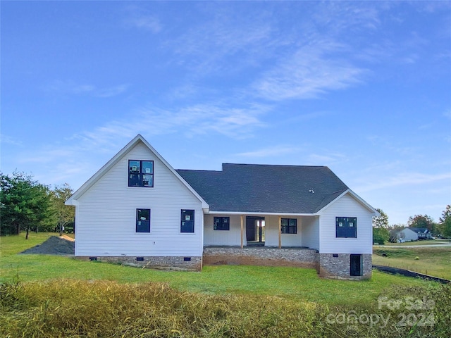 back of property with a lawn and covered porch