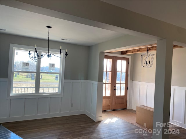 interior space featuring a chandelier, french doors, and wood-type flooring