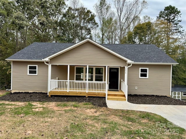 ranch-style house featuring covered porch and roof with shingles