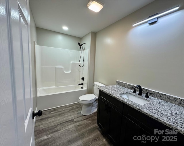 bathroom with toilet, vanity, shower / tub combination, and wood finished floors