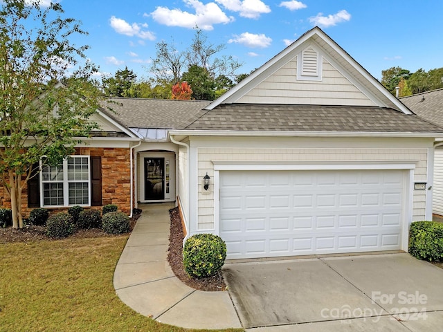 ranch-style home featuring a garage and a front lawn