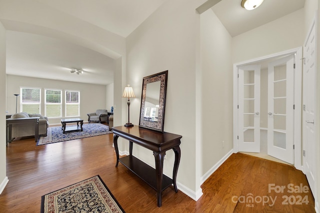 hallway featuring hardwood / wood-style flooring and vaulted ceiling