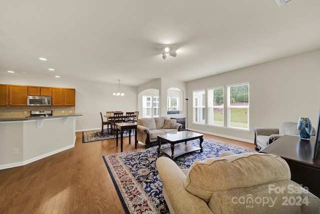 living room featuring a notable chandelier and light wood-type flooring