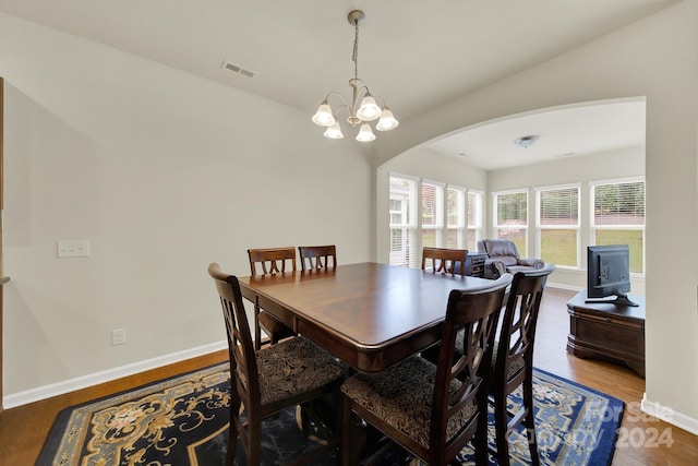 dining space with hardwood / wood-style flooring and a notable chandelier