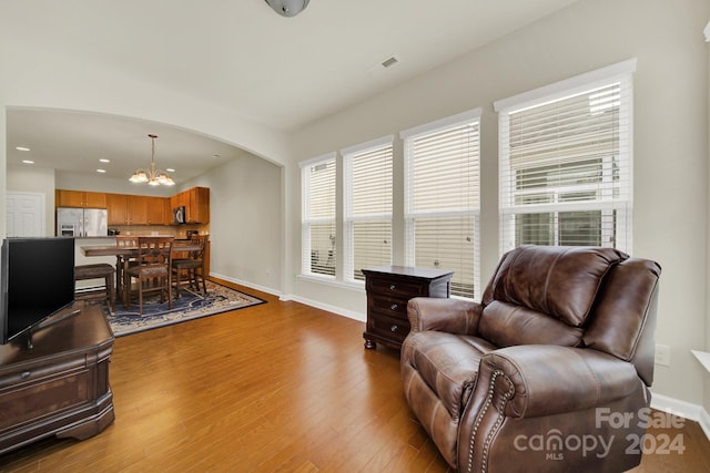 living room with light wood-type flooring and a chandelier