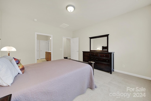 bedroom with light colored carpet and ensuite bathroom