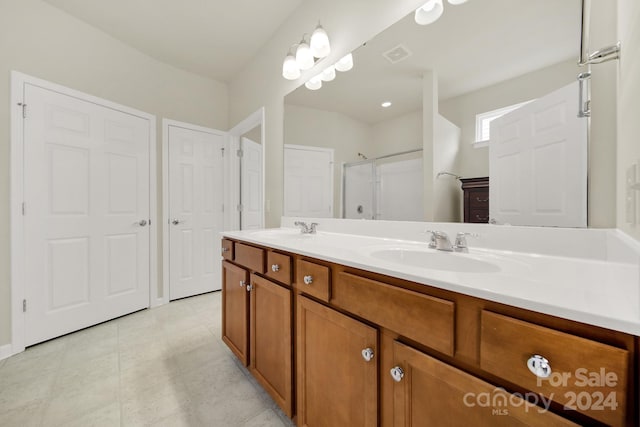 bathroom featuring walk in shower, vanity, and tile patterned floors