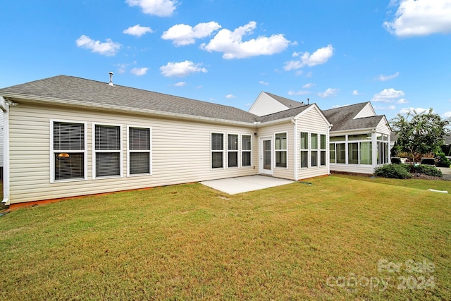 rear view of house featuring a sunroom, a yard, and a patio