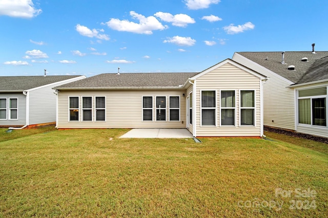 rear view of property featuring a patio and a lawn