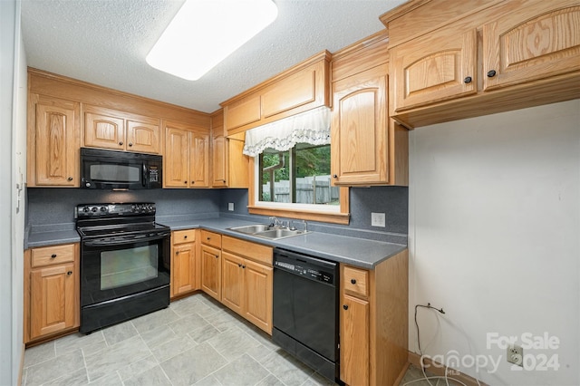 kitchen featuring a textured ceiling, black appliances, and sink