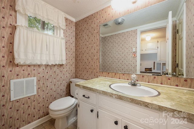 bathroom with toilet, ornamental molding, vanity, and a textured ceiling