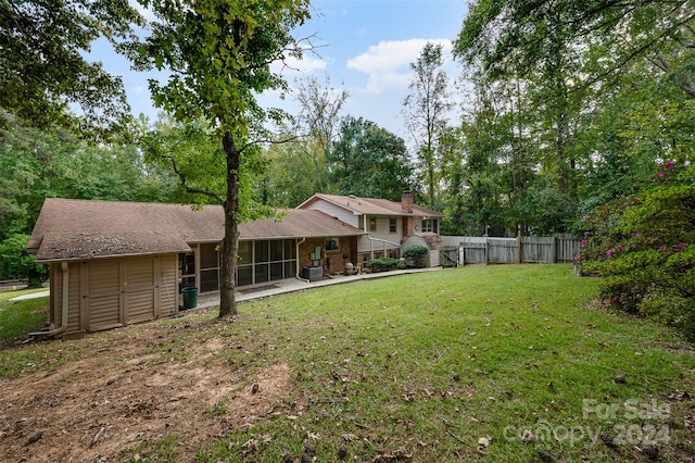 view of yard featuring a sunroom and a storage shed