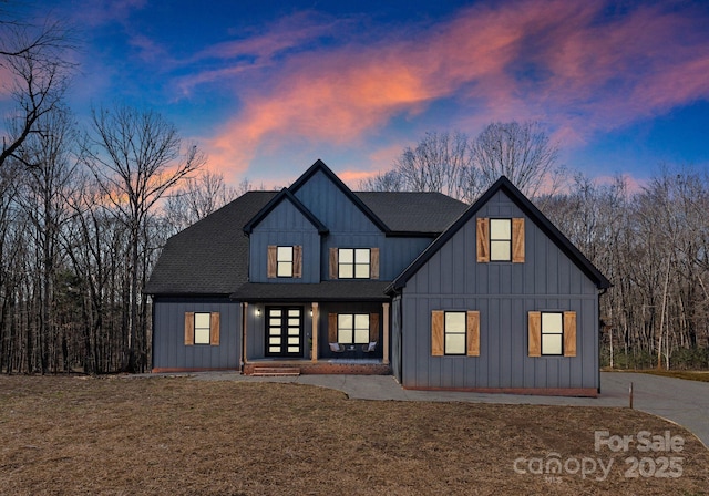 back house at dusk with a yard and french doors