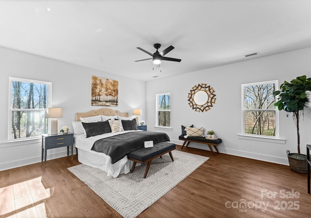 bedroom featuring multiple windows, dark hardwood / wood-style flooring, and ceiling fan