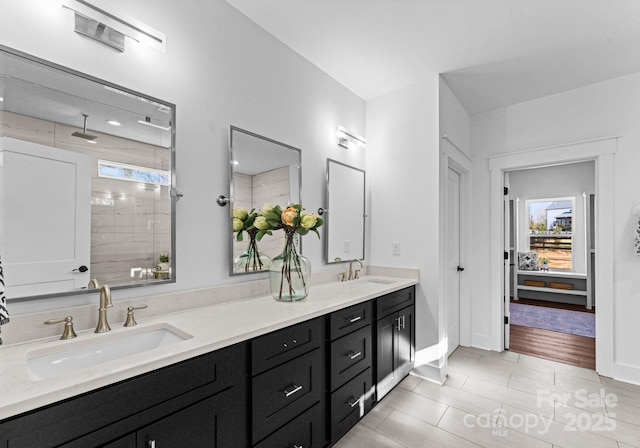 bathroom with tile patterned floors, vanity, and a tile shower