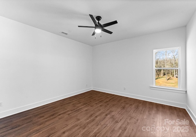 empty room featuring ceiling fan and dark wood-type flooring