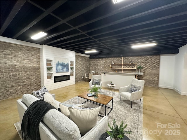 living room featuring a fireplace, concrete floors, built in features, and brick wall