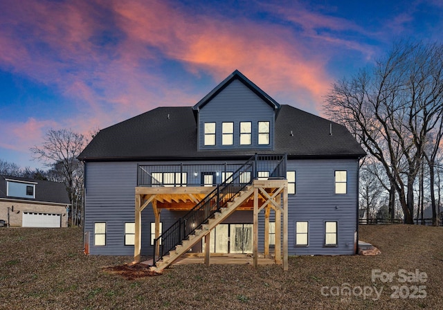 back house at dusk featuring a wooden deck