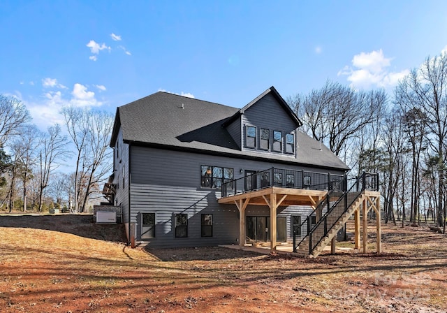 back of property featuring a deck and a lawn