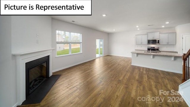 unfurnished living room with dark wood-type flooring