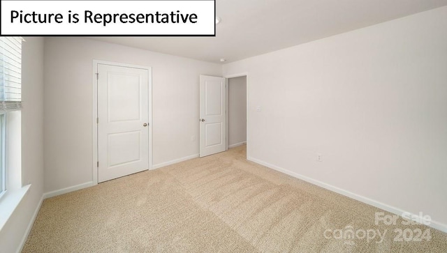 unfurnished bedroom with light colored carpet