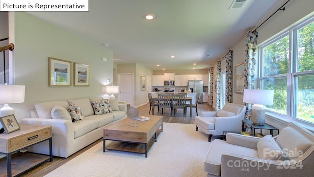 living room with light hardwood / wood-style floors and a healthy amount of sunlight