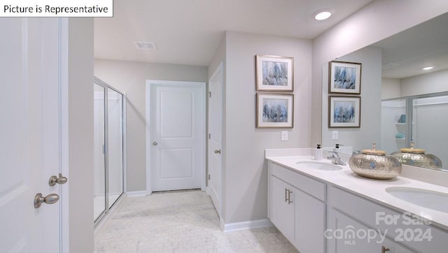 bathroom with a shower with door, tile patterned floors, and vanity