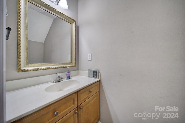 bathroom with vanity and vaulted ceiling