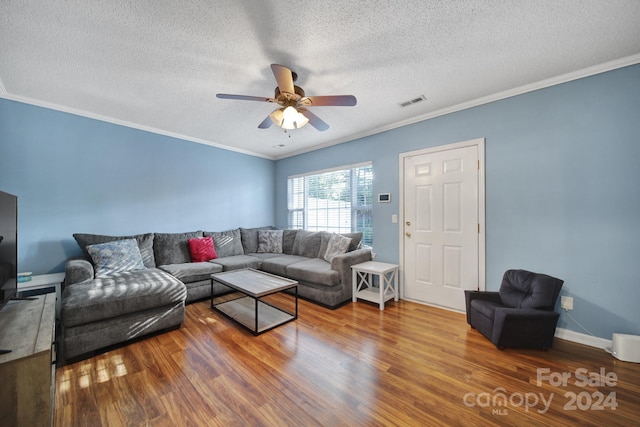 living room featuring ornamental molding, hardwood / wood-style floors, a textured ceiling, and ceiling fan