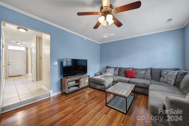 living room featuring ornamental molding, hardwood / wood-style floors, a textured ceiling, and ceiling fan