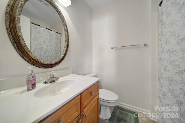 bathroom with vanity, walk in shower, and toilet