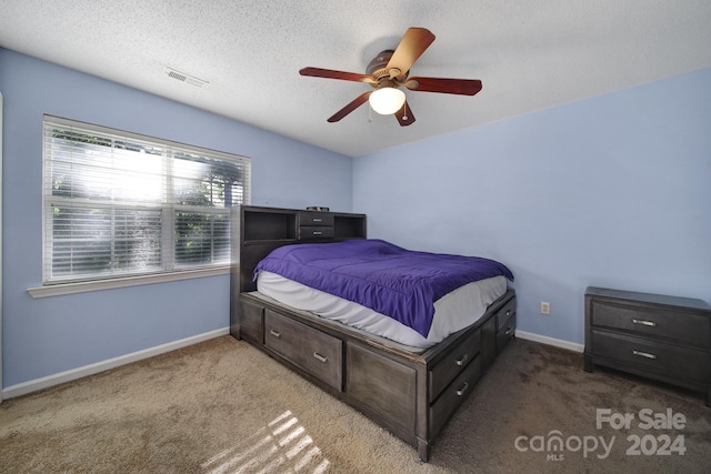 bedroom with a textured ceiling, carpet flooring, and ceiling fan